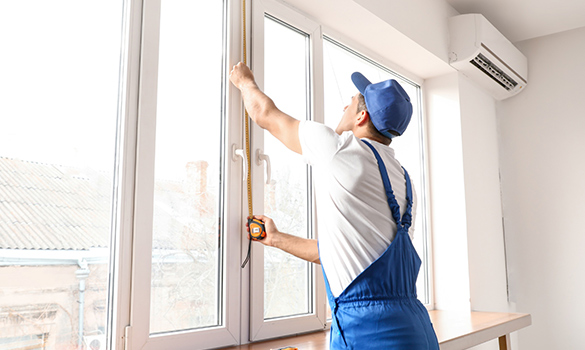 man measuring window height