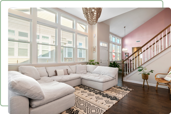 living room with a large white couch in front of a wall of windows