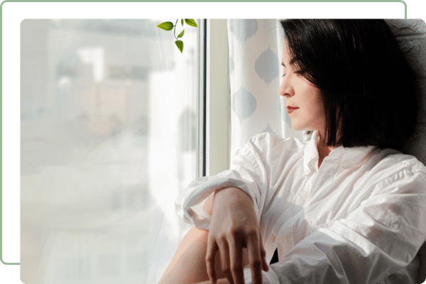 lady sitting next to and looking out of a window